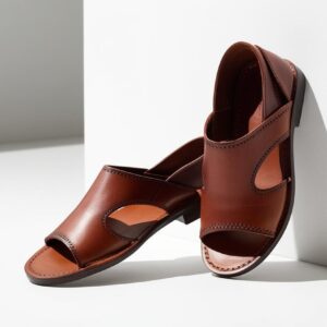 Pair of handcrafted African leather sandals with minimal stitching detail, floating on clean white background, no shadows